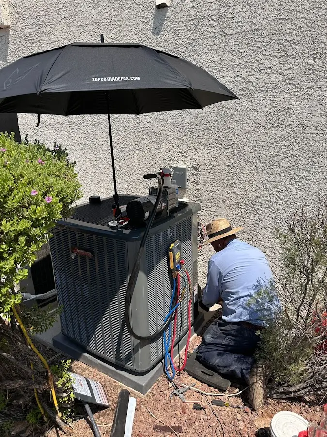 HVAC technician performing outdoor AC maintenance in Fort Knox