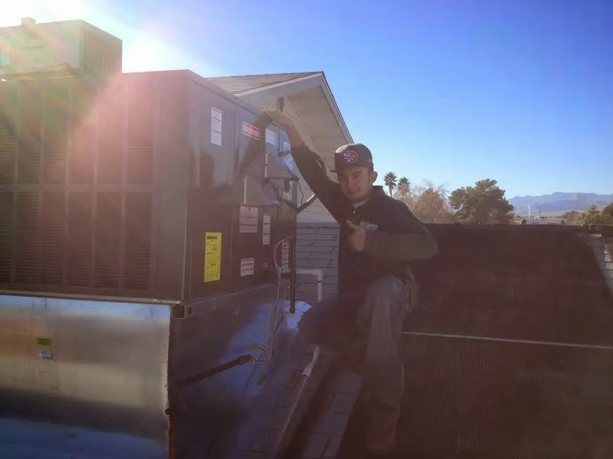HVAC technician performing Boiler Repair on a rooftop unit in Fort Knox